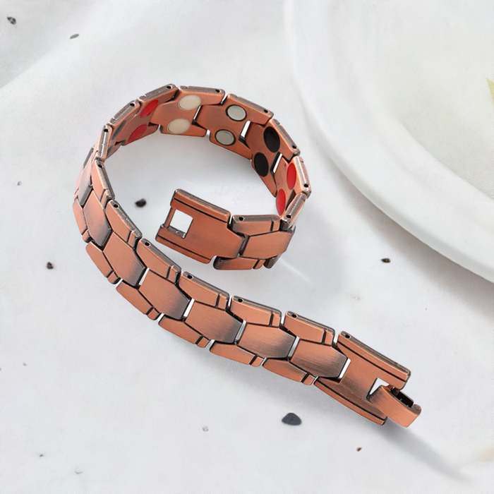 Pulsera magnética elegante sobre fondo neutro color bronce